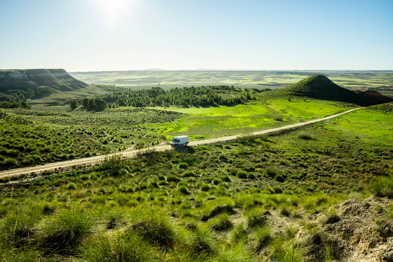 A Toyota Proace drives a long country road